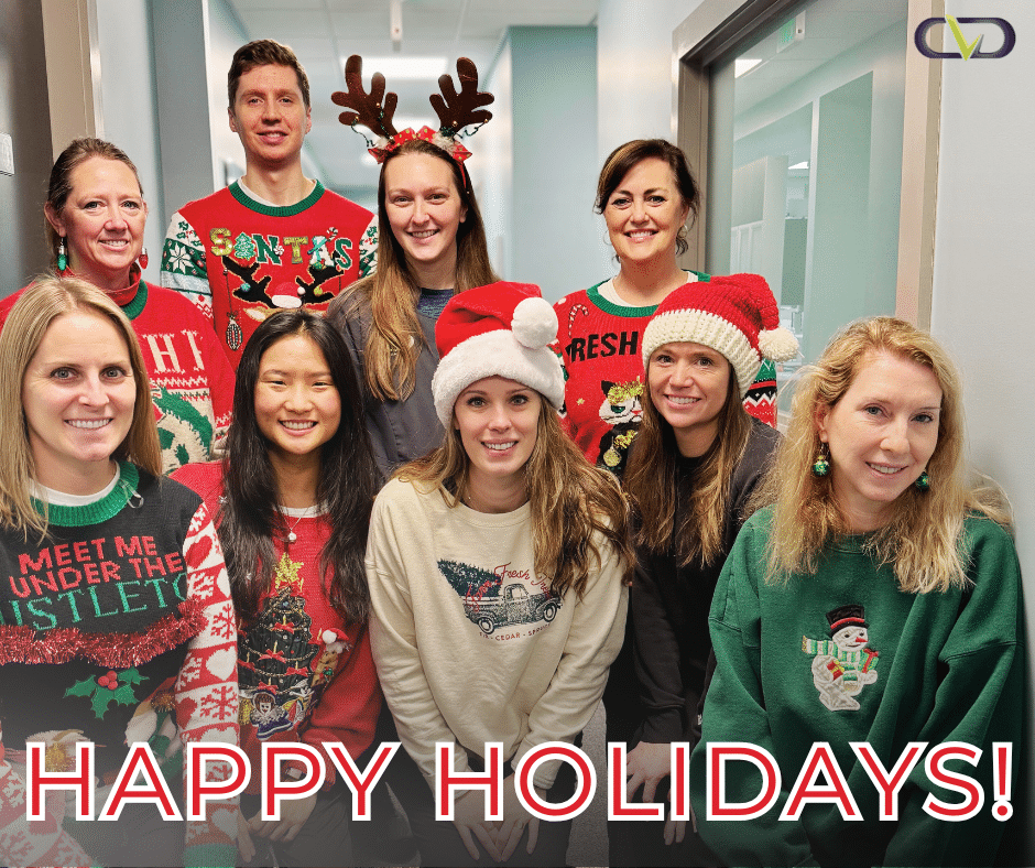 Staff in holiday sweaters with Happy Holidays written