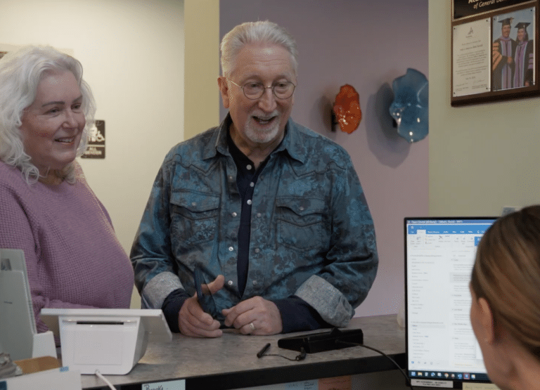 An older couple at the front desk of the office